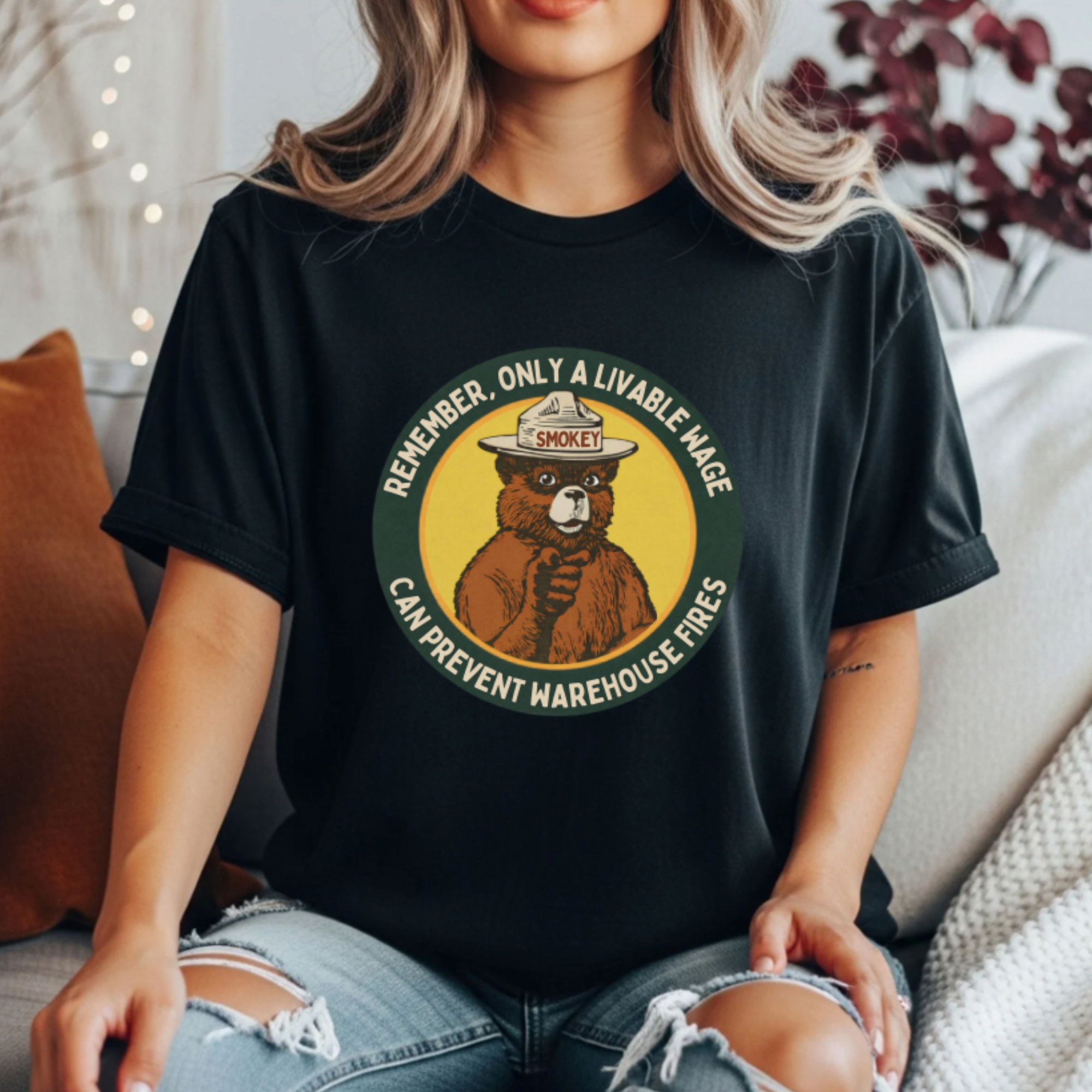 Black graphic tee featuring a Smokey Bear parody badge design. Text reads “Remember, Only a Livable Wage Can Prevent Warehouse Fires.” Funny labor rights shirt, workers’ rights tee, sarcastic anti-Amazon shirt, pro-union graphic tee, funny political gift.