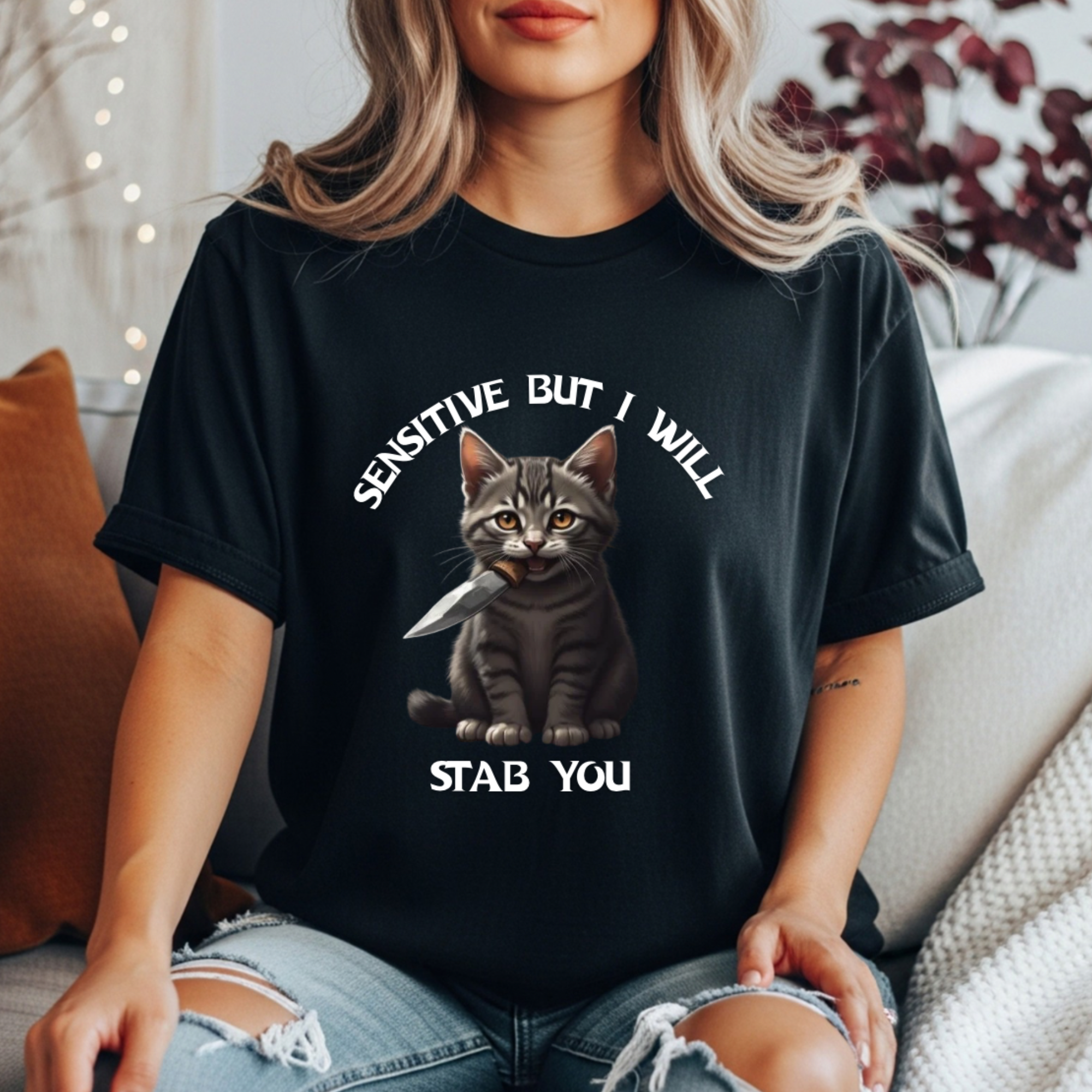 Women’s black t-shirt with a cat graphic and text that reads “sensitive but I will stab you”