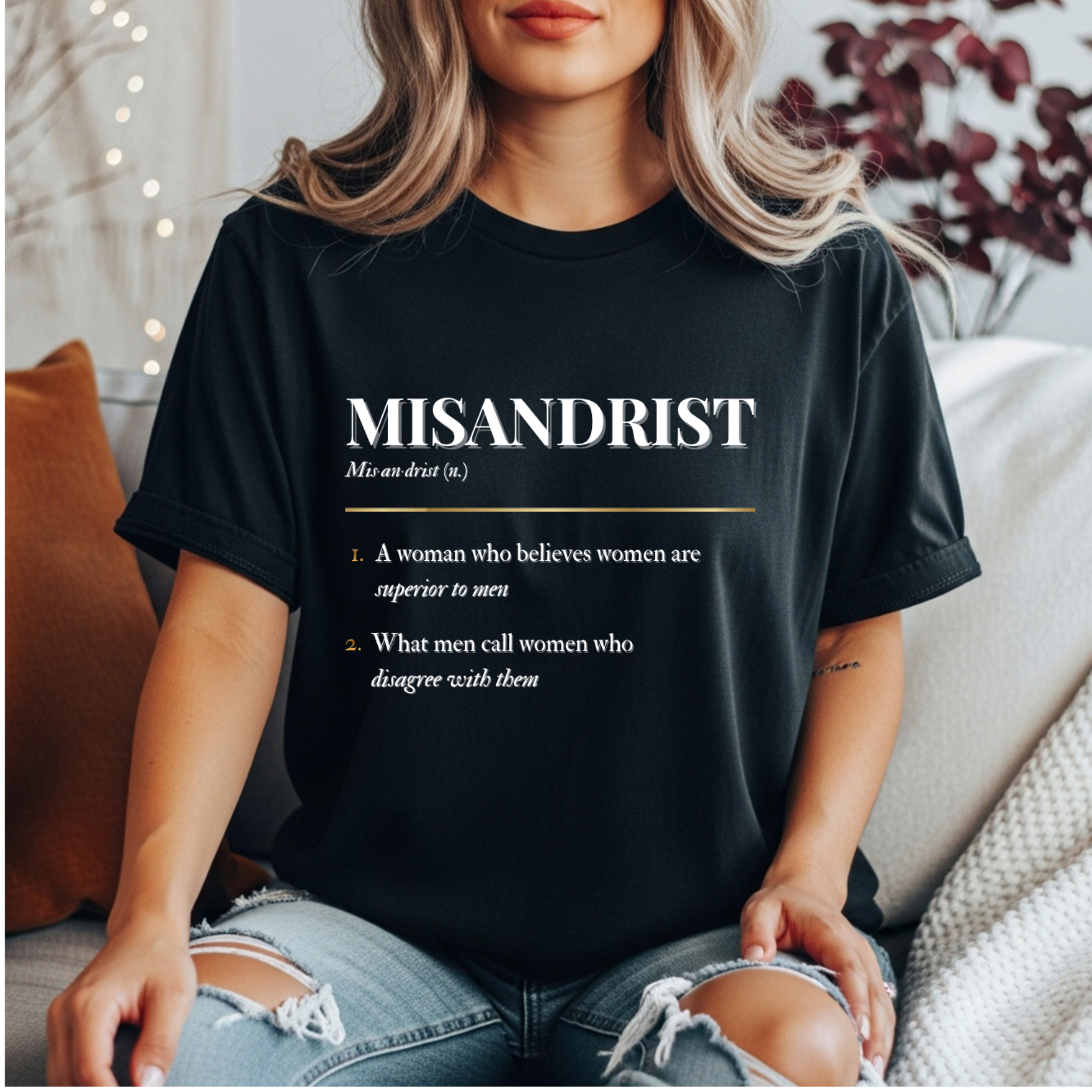 black Misandrist definition t-shirt with gold and white dictionary-style text reading ‘A woman who believes women are superior to men’ and ‘What men call women who disagree with them’ — feminist statement tee by Glitter and Rage”