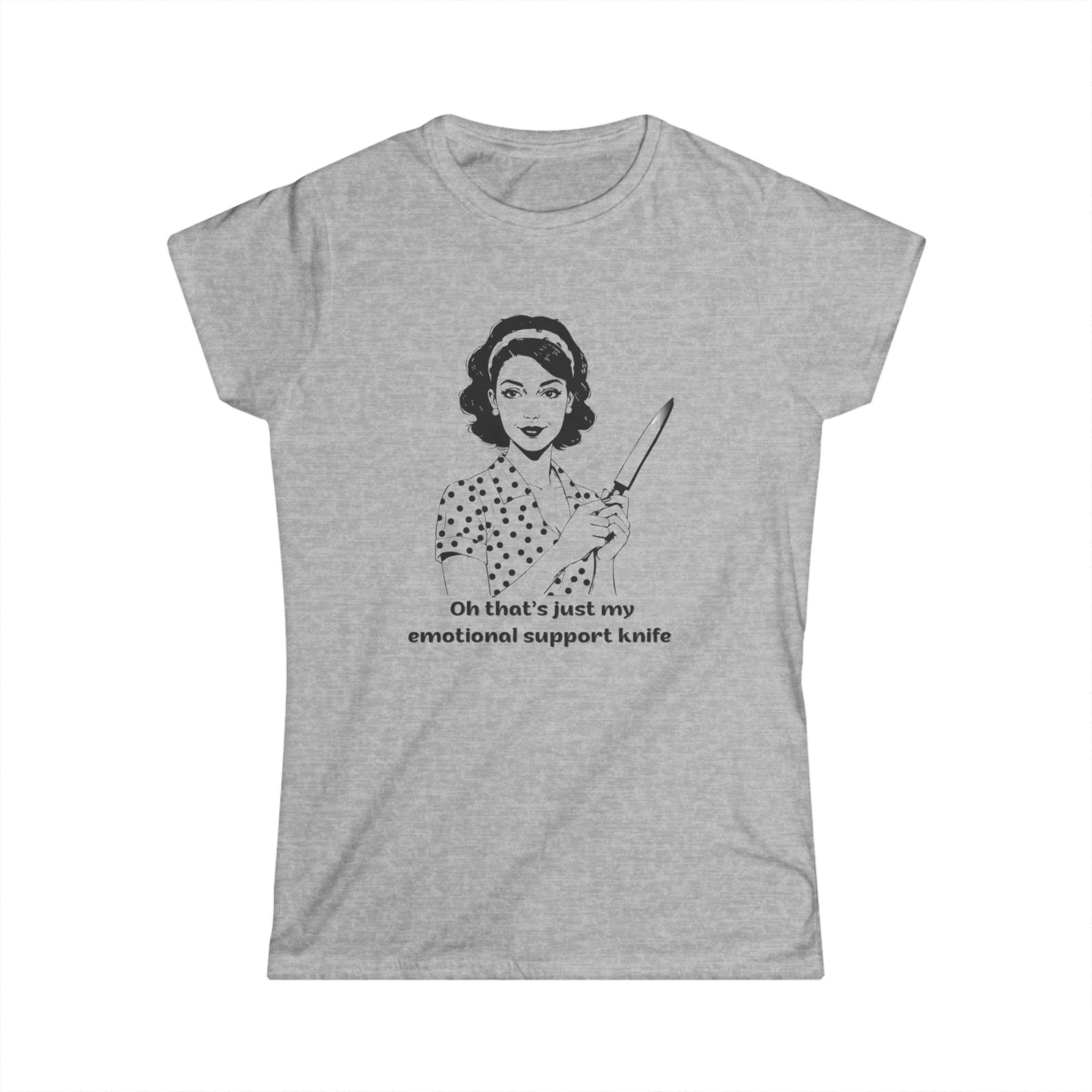 Gray  t-shirt featuring a vintage-style black line illustration of a 1950s housewife in a polka dot dress holding a large kitchen knife, with the text: “Oh that’s just my emotional support knife.”